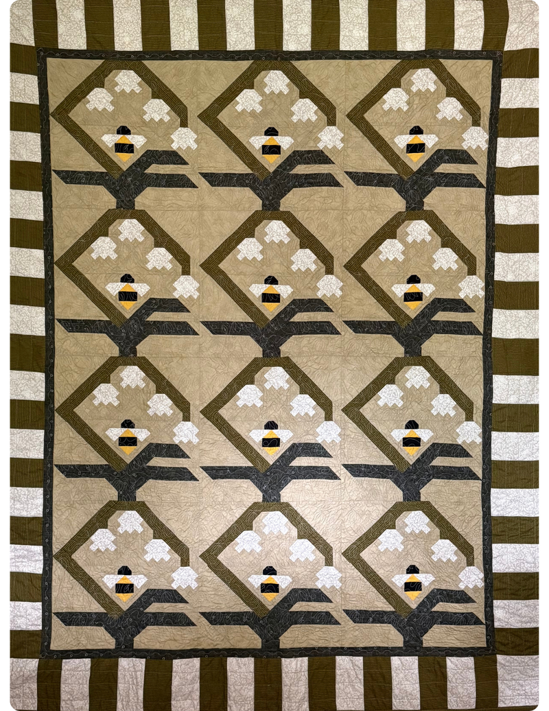 Full view of quilt with green and white stripe border. 3x4 flower and bee quilt block in the center.
