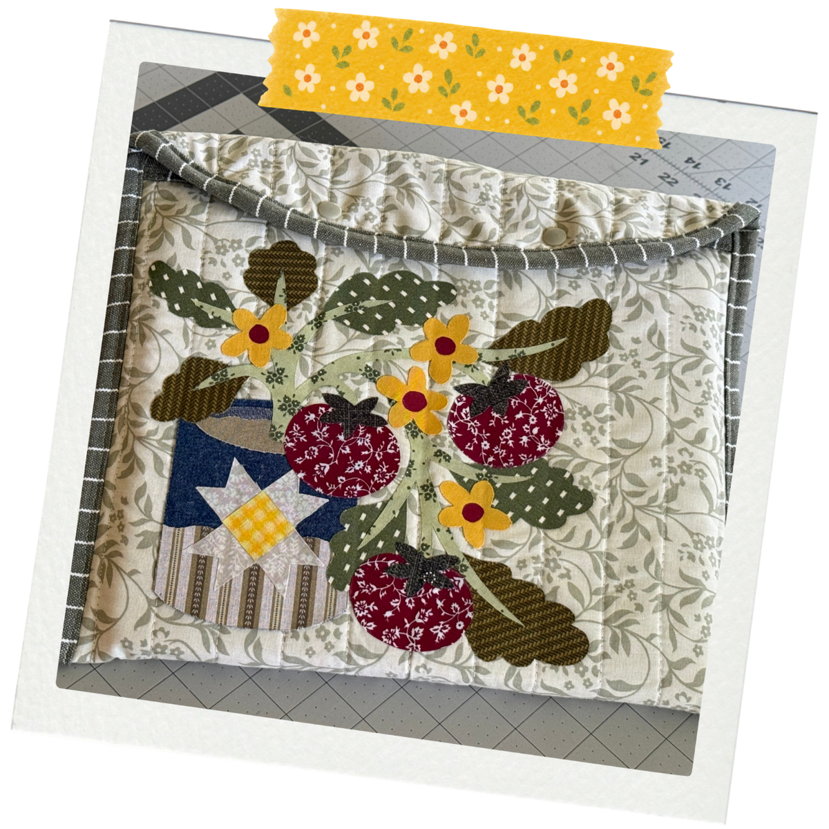 Laptop Sleeve with Tin of Tomato Appliqué inside of a polariod fram with a floral pattern washi tape on the top.