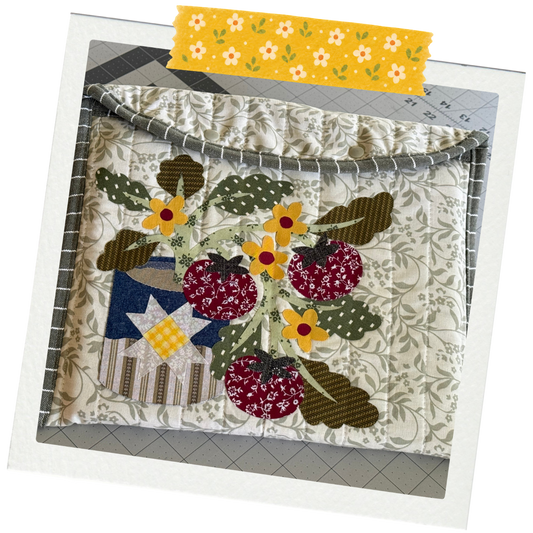 Laptop Sleeve with Tin of Tomato Appliqué inside of a polariod fram with a floral pattern washi tape on the top.